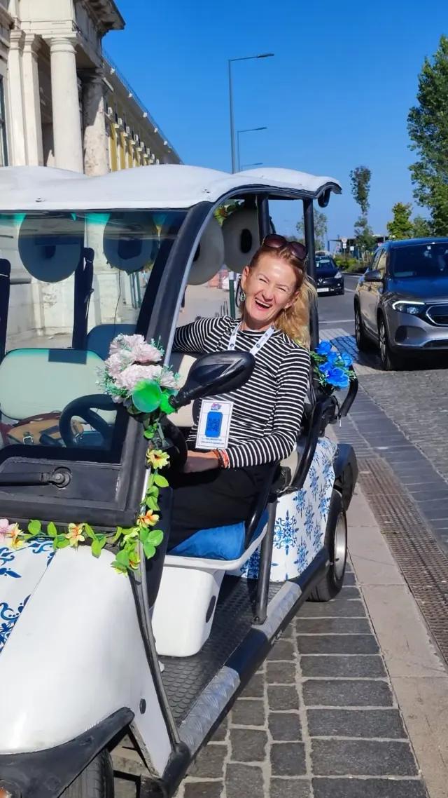 Cliente sorridente a bordo do tuk-tuk decorado com flores