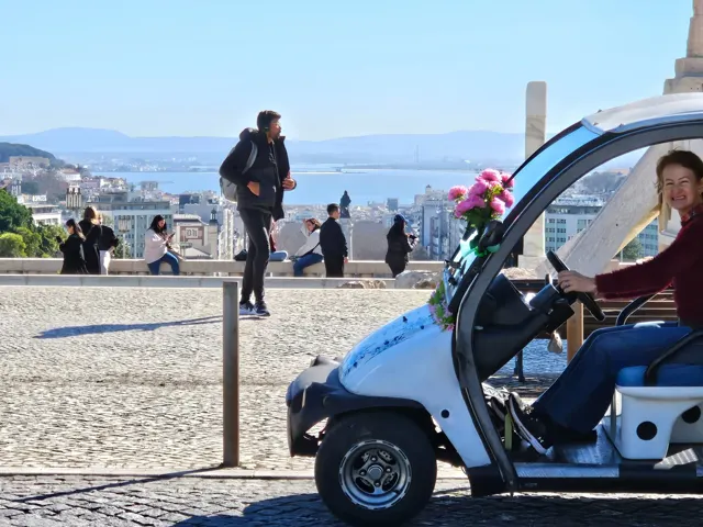A guia Susane ao volante do tuk-tuk florido num miradouro