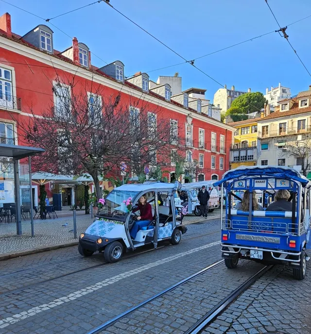 Dois tuk-tuks elétricos junto aos elétricos históricos de Alfama