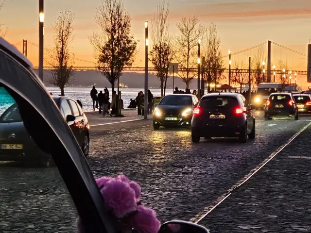 Un convoglio di tuk-tuk elettrici in una strada di Lisbona al tramonto