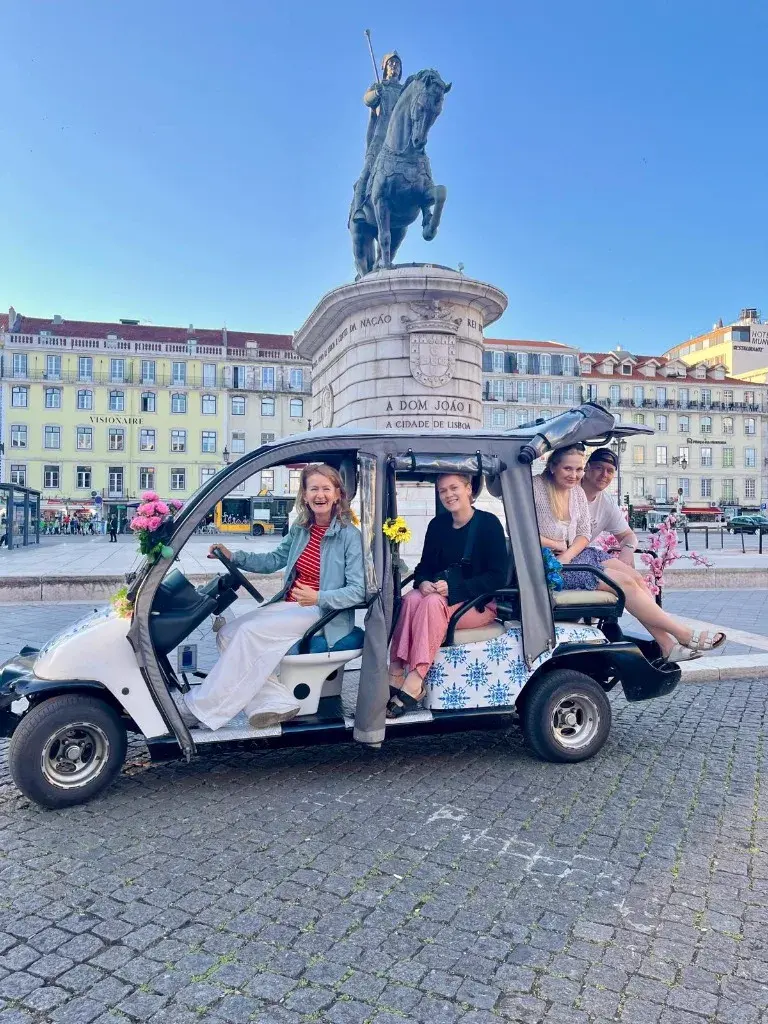 Turistas felizes num tour de tuk-tuk elétrico em Lisboa