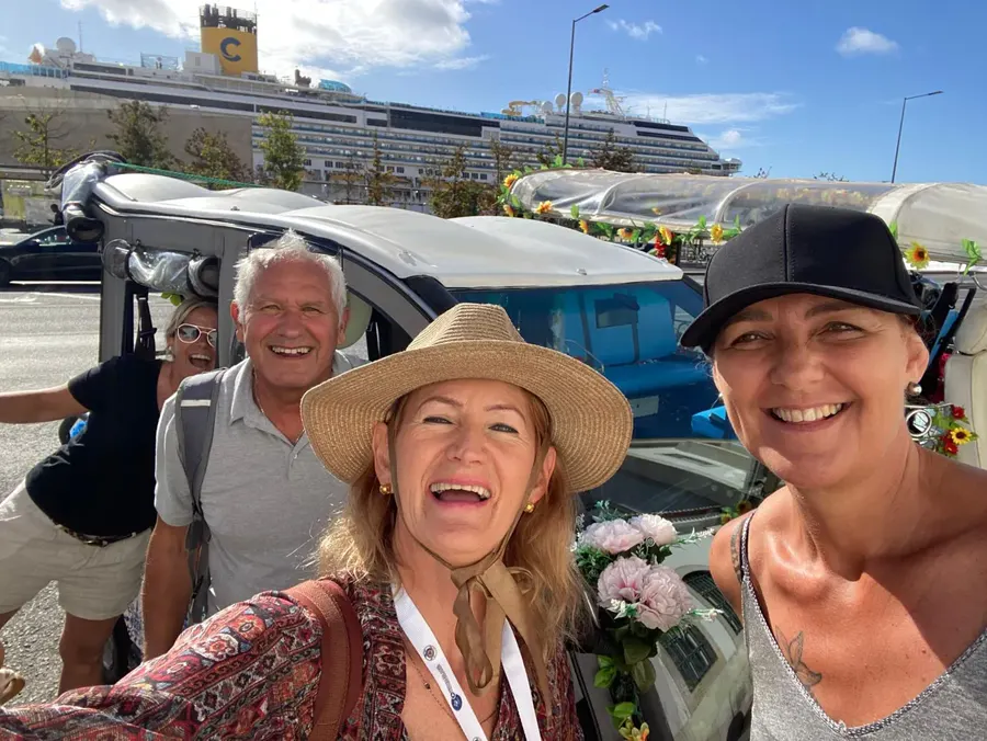 Groupe à côté du tuk-tuk fleuri au terminal de croisière de Lisbonne, avec le navire derrière